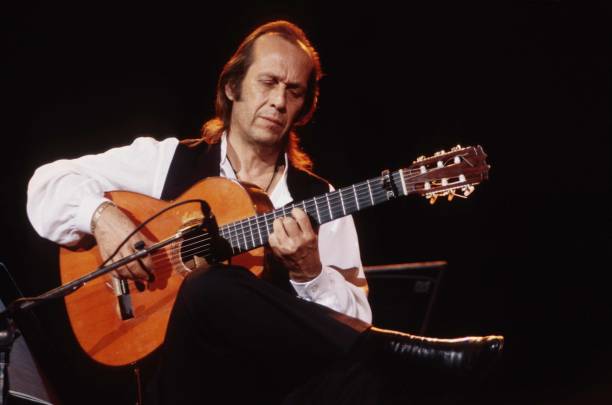 guitarrista en una silla tocando con un micro